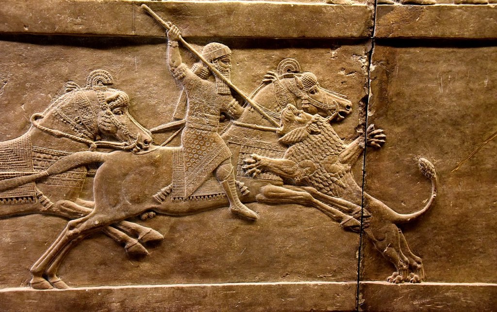 Ashurbanipal on his horse thrusting a spear at a lion’s head.