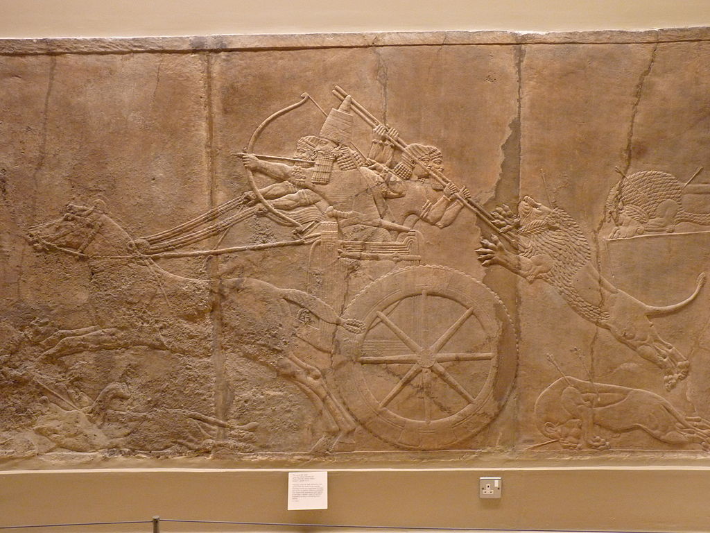 The king shoots arrows from his chariot, while huntsmen fend off a lion behind.